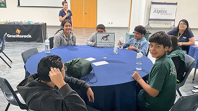 Student sitting at table with blue table cloth